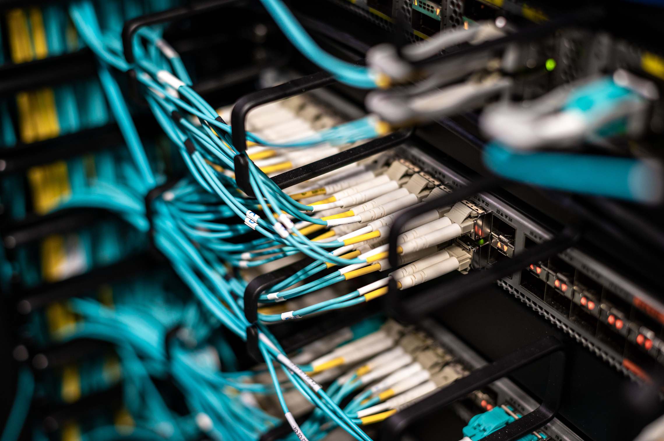 แถวตู้เซิร์ฟเวอร์และสายเคเบิลในห้องศูนย์ข้อมูล rack data center network